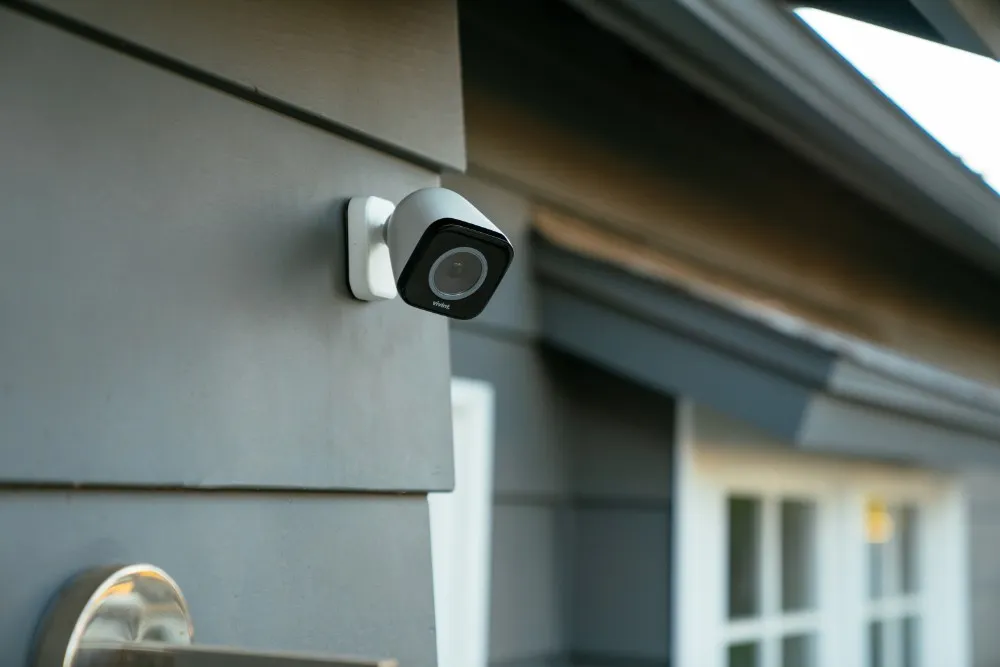 home security camera system installation on siding by window of home